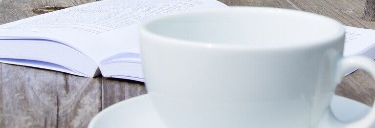 Buch und Kaffeetasse