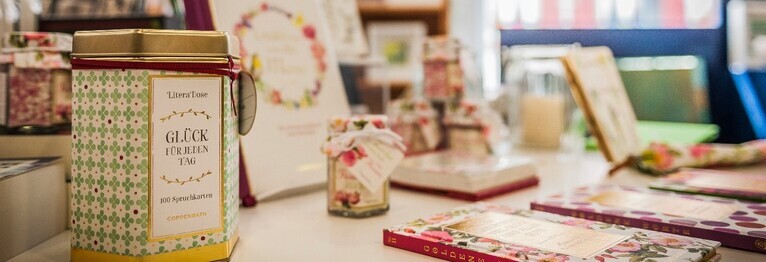Weißer Tisch dekoriert mit Büchern und Geschenkartikeln