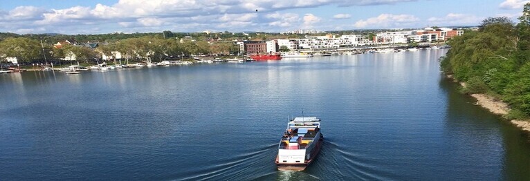 Ein Boot fährt in den Schiersteiner Hafen ein. Blick auf Schierstein