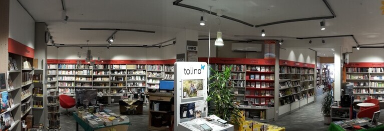Erdgeschoss der Buchhandlung mit Buchregalen, Arbeitsplatz und Tolinostation